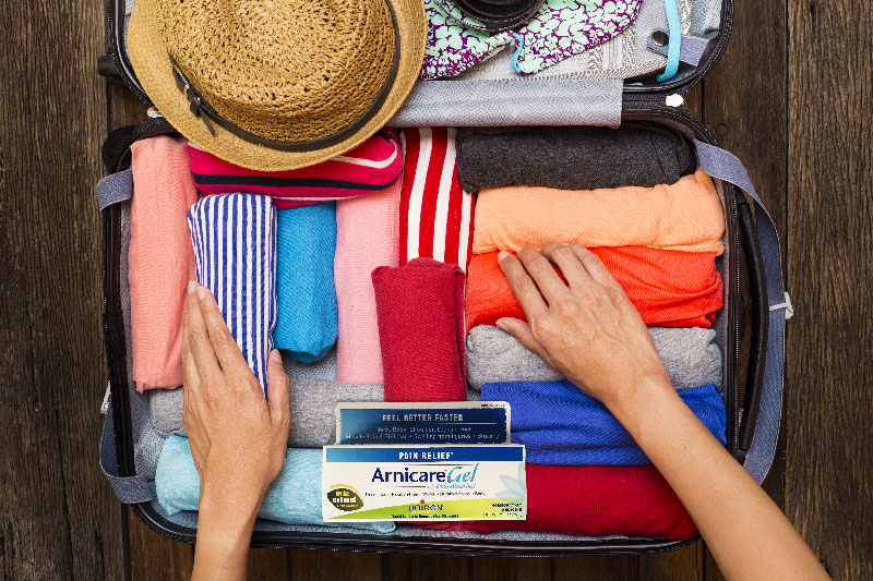 woman packing for trip with arnicare